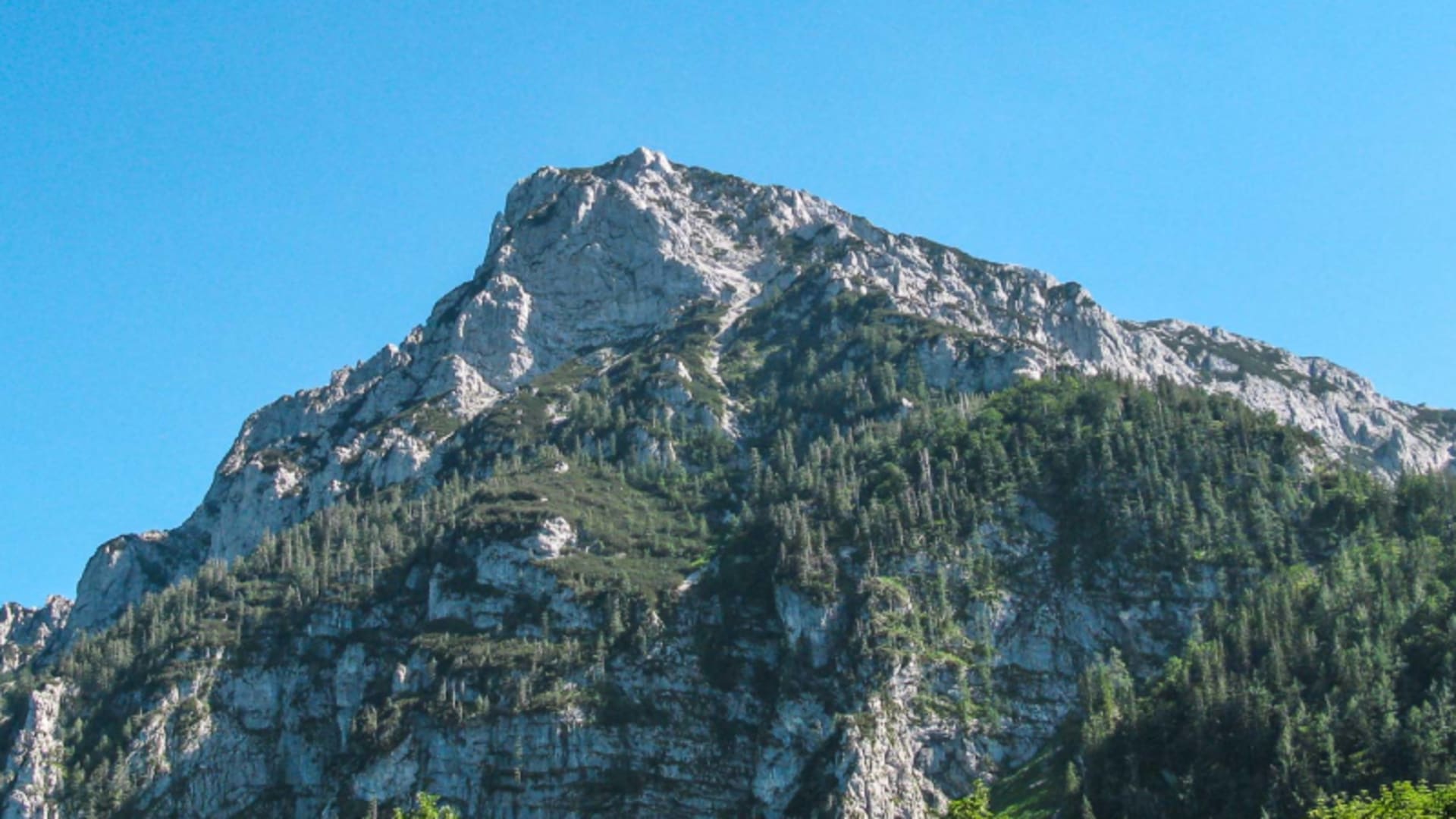 Blick von unten auf den zerklüfteten Kalkfelsgipfel des Hohen Staufen für den Pidinger Klettersteig.
