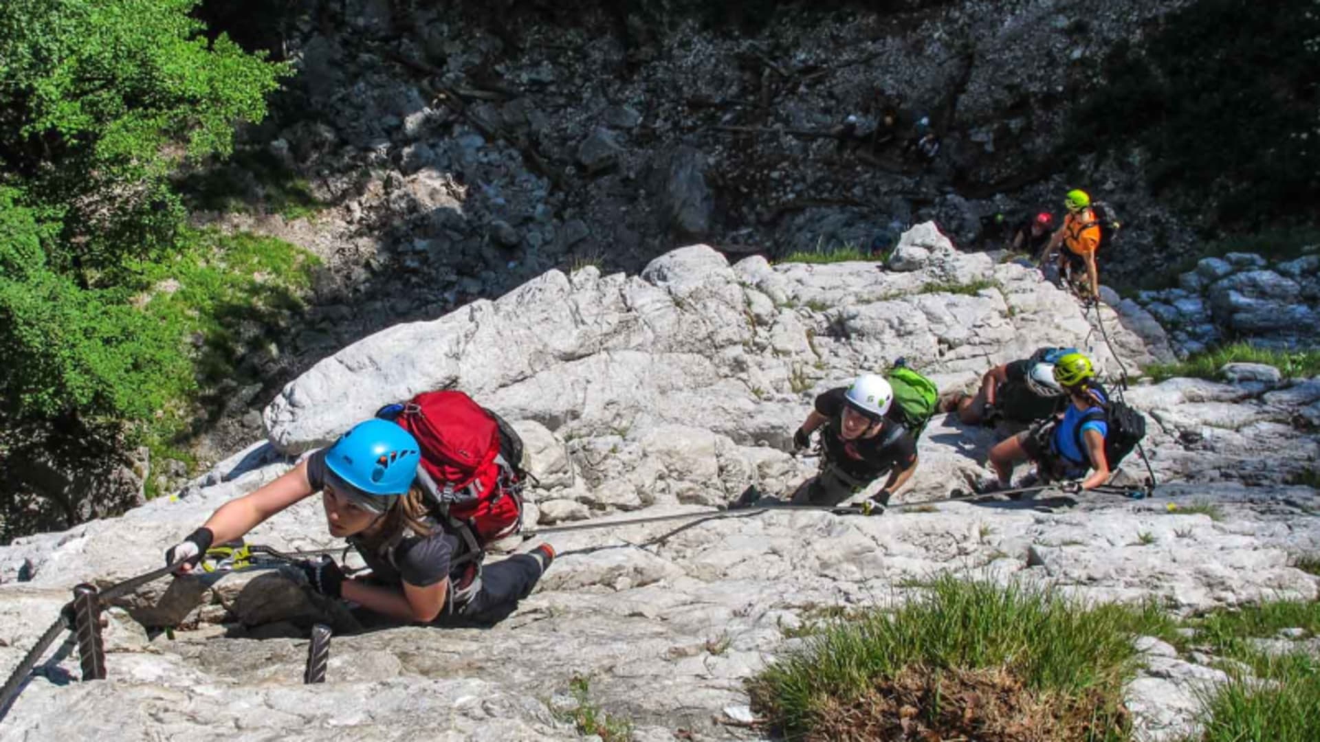 Klettersteigkurs Berchtesgaden: Gruppe klettert an Stahlseil und Trittstiften über hellen Kalkfels aufwärts.