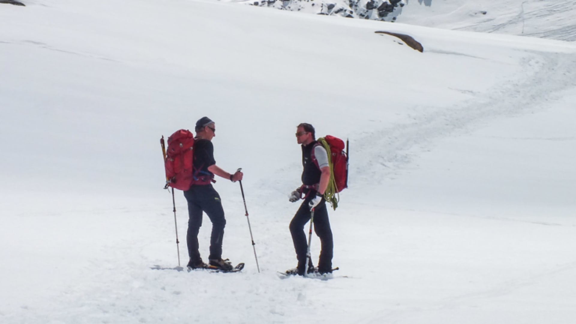 Zwei Schneeschuhwanderer machen eine Pause auf einem verschneiten Hang nahe der Zufallhütte im Ortlergebiet.