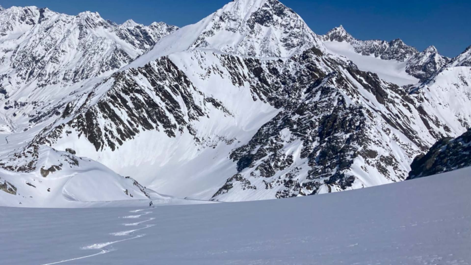 Skitourengeher zieht eine gerade Aufstiegsspur über ein weites Schneefeld am Daunkogel.