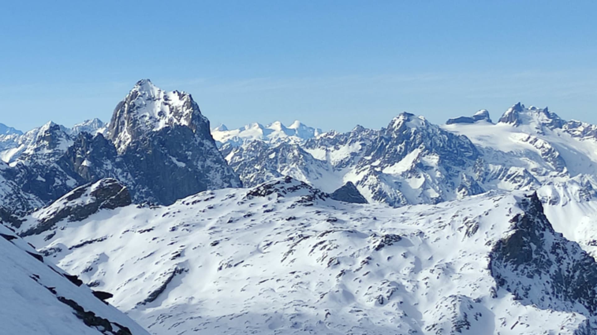 Skitour am Clariden: Blick über ein hochalpines Gletscherplateau auf die verschneite Gipfelkette im Hintergrund