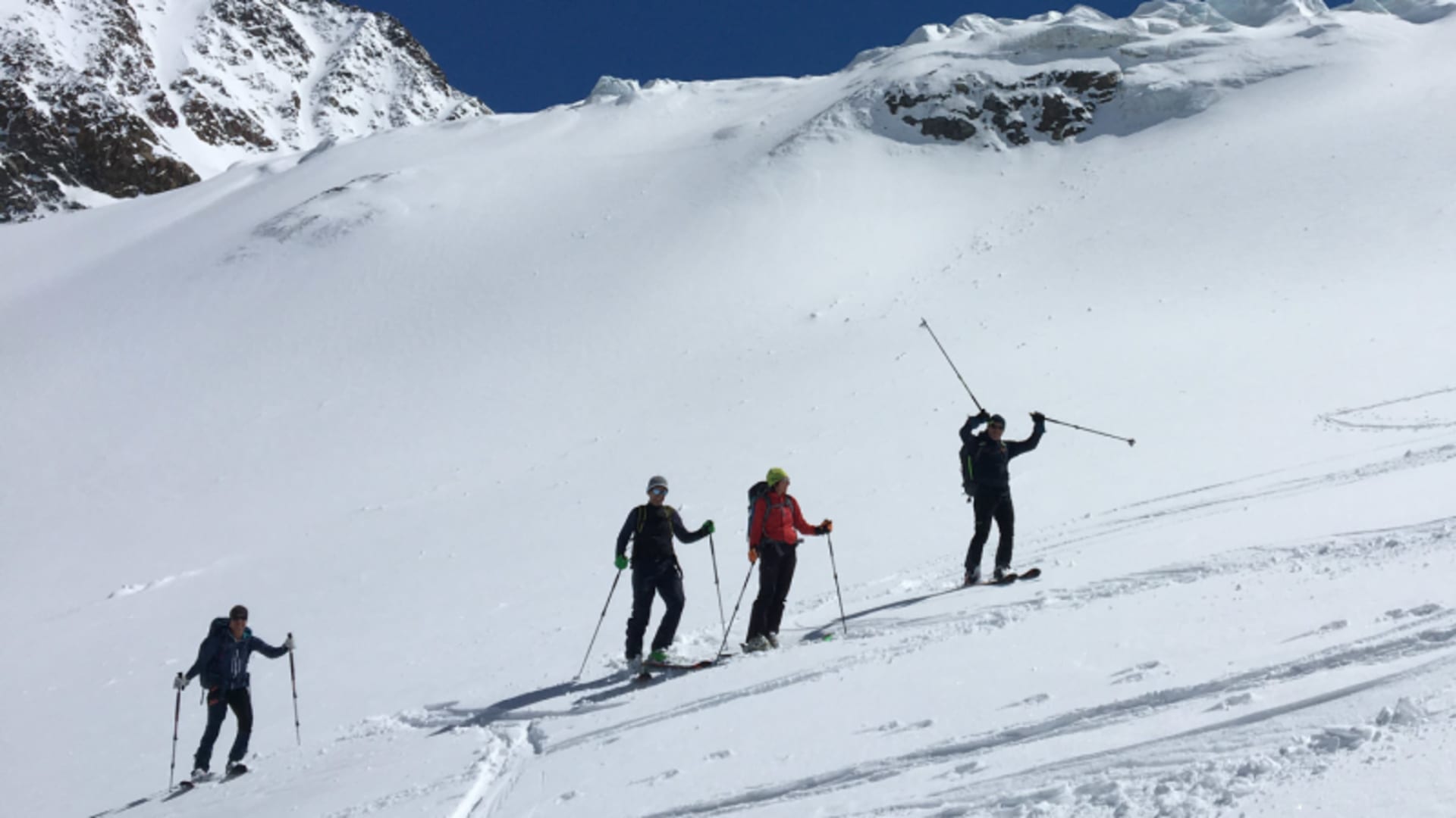 Vier Skitourengeher mit Fellen steigen am Sulztalferner einen steilen Gletscherhang auf.