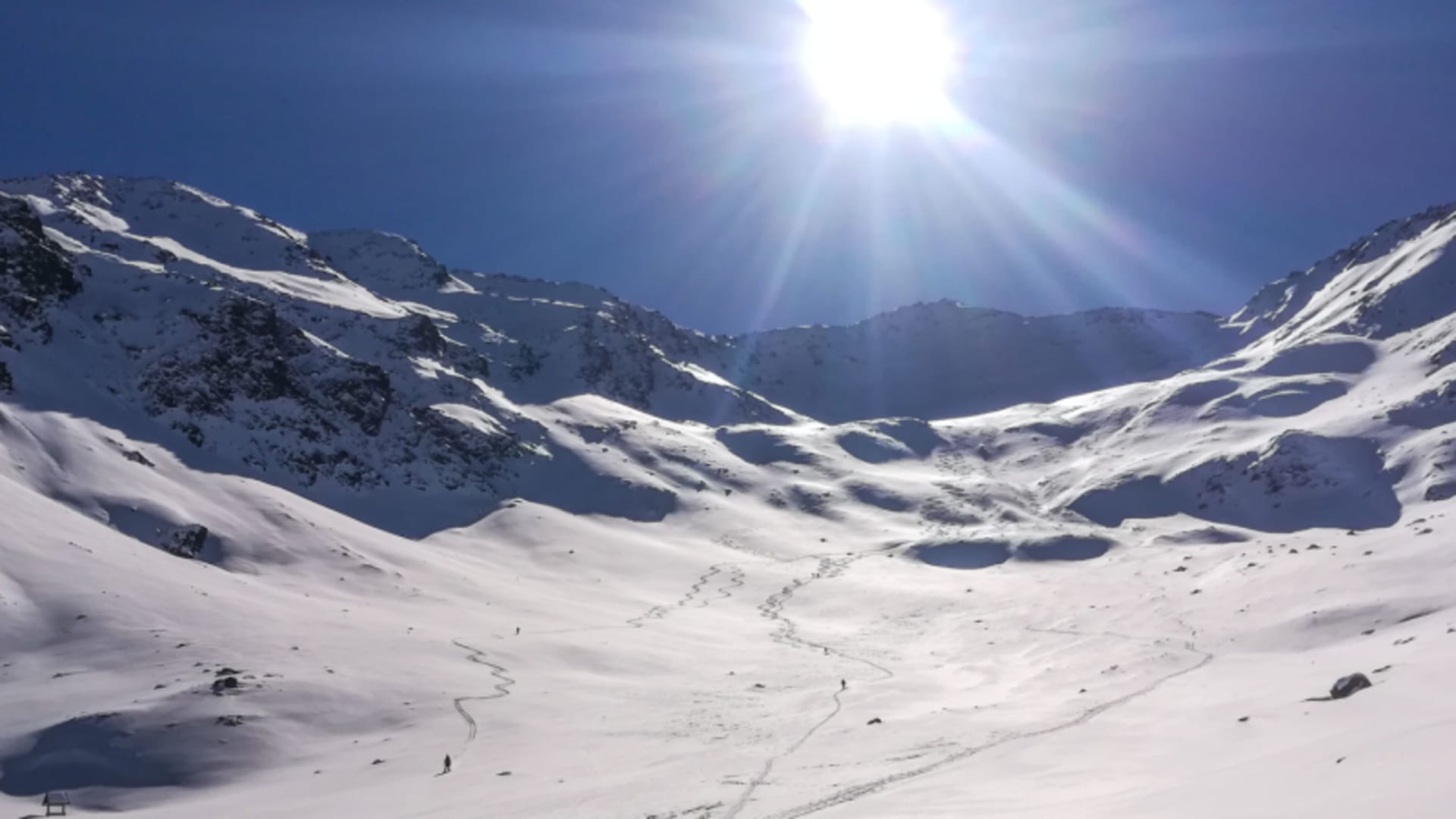 Drei Skitourengeher ziehen Aufstiegsspuren durch das vollständig verschneite Hochtal Langtaufers im Vinschgau.