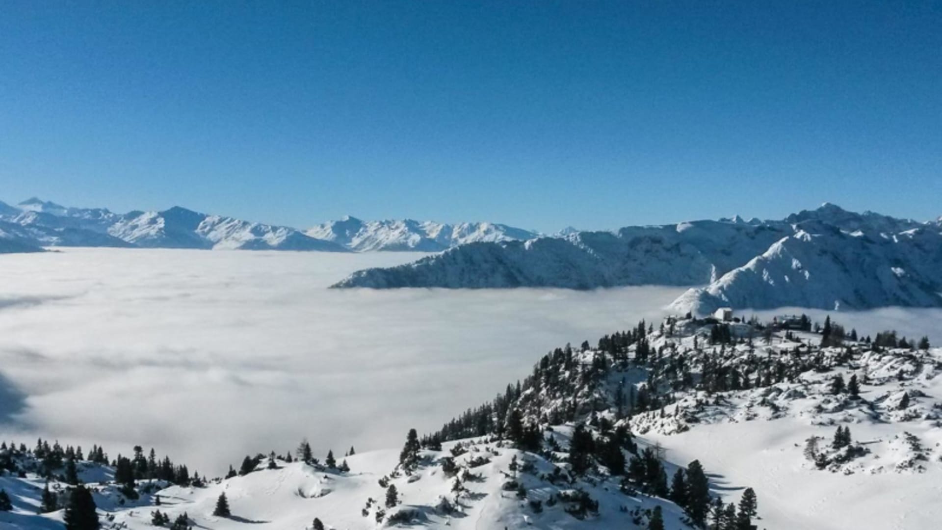 Skitour am Achensee: Panorama mit Nebelmeer über dem Tal und schneebedeckten Karwendelgipfeln im Hintergrund.