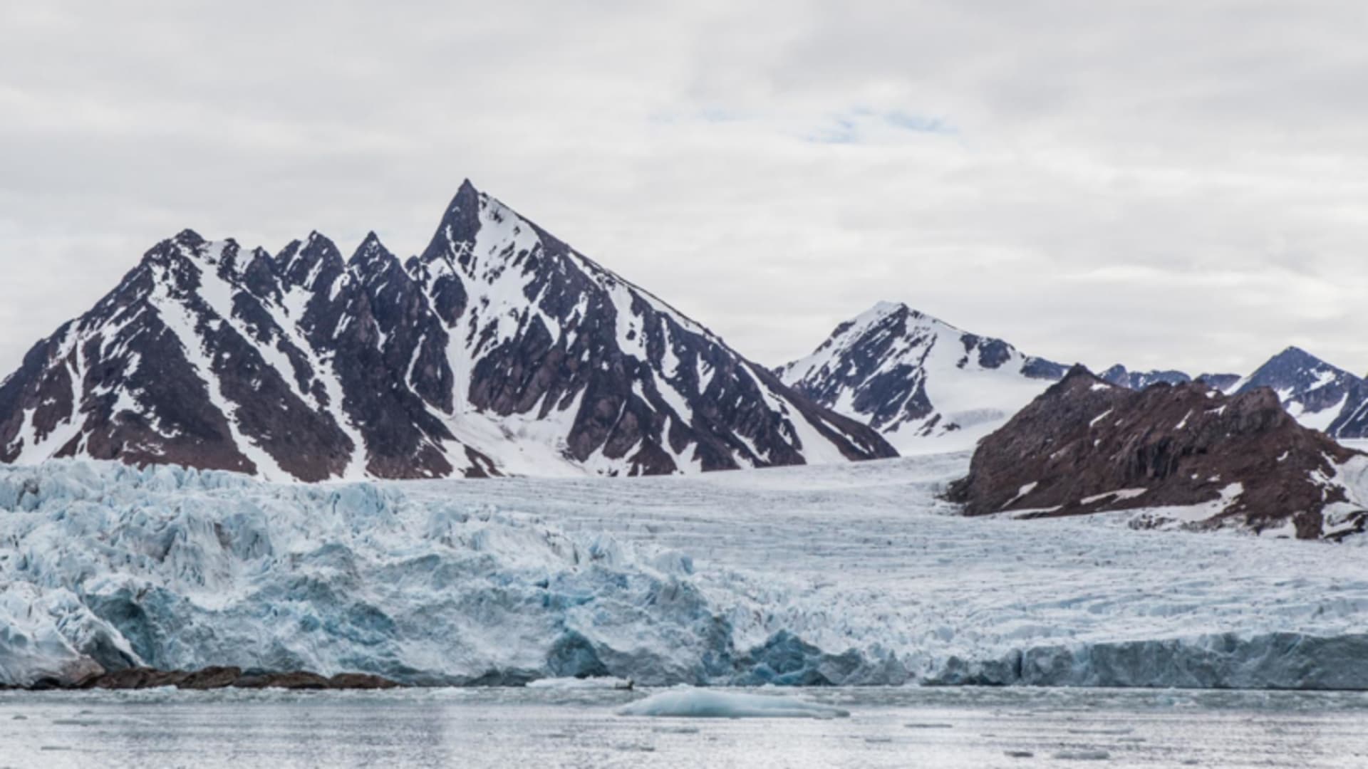 Skitour Spitzbergen: Panorama einer arktischen Gletscherfront mit treibenden Eisschollen, zerklüfteter Gletscherzunge