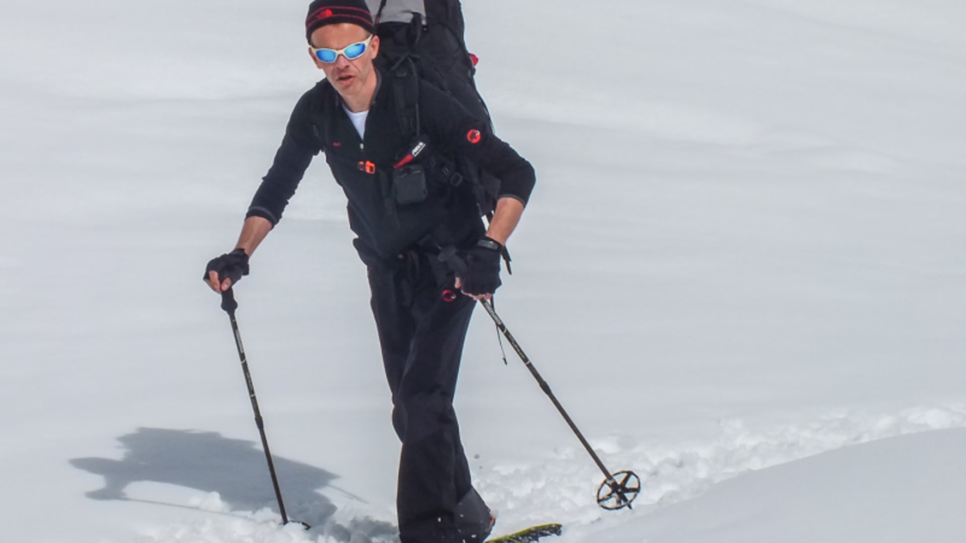 Person mit Tourenski und Rucksack beim Aufstieg auf verschneitem Hang – Winterwanderung in den Berchtesgadener Alpen mit Fellen