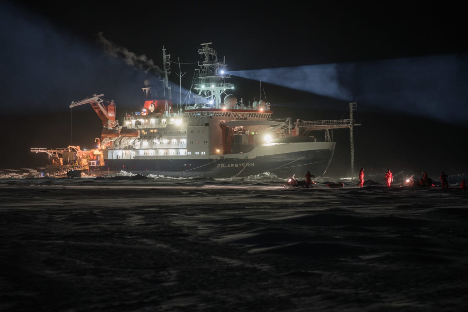 Expedition Polarstern im Packeis des Arktischen Ozeans bei Nacht, beleuchtet mit Suchscheinwerfer.