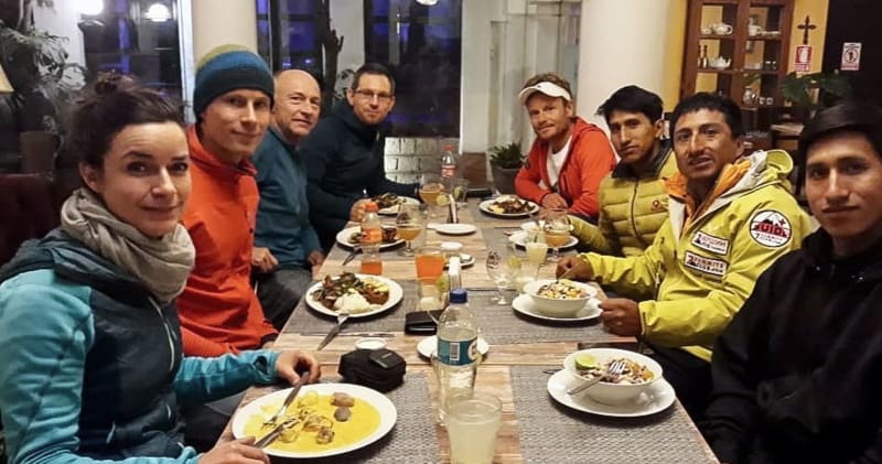 Expedition Alpamayo: Acht Höhenbergsteiger beim gemeinsamen Abendessen am Tisch in Peru.