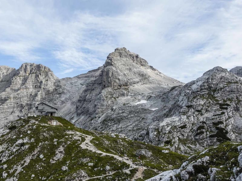 Bergwanderung Salzburg–Triest: Schutzhaus auf Felssporn zwischen Kalksteingipfeln an der Alpenüberquerung