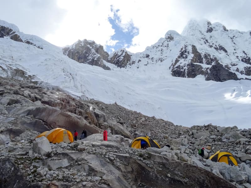Expedition Alpamayo: fünf Kuppelzelte auf Moränengelände mit vergletscherter Bergkulisse am Alpamayo in Peru.