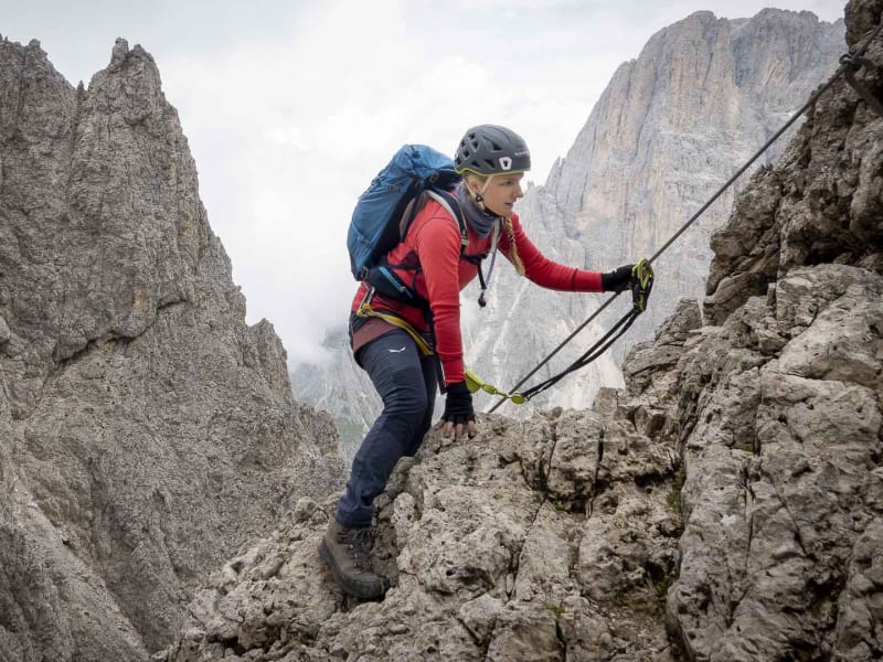 Klettersteiggeher greift am Drahtseil des Oskar-Schuster-Steigs an der Sella-Gruppe in den Dolomiten aufwärts