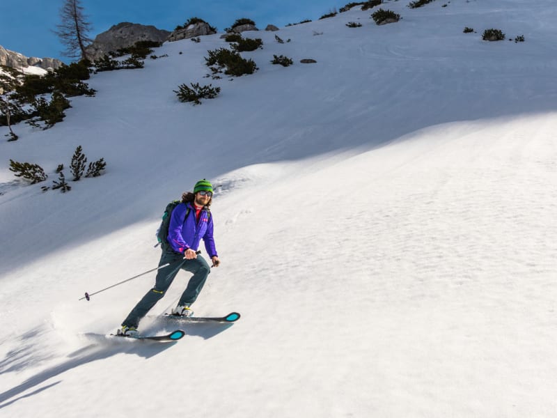 Ein Skitourengeher fährt auf einem offenen Firnhang der Haute Route Berchtesgaden ab.