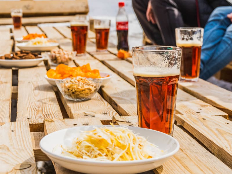 Holztisch mit Speisen und Getränken auf einer Außenterrasse bei Skitouren in Kirgistan im Winter.