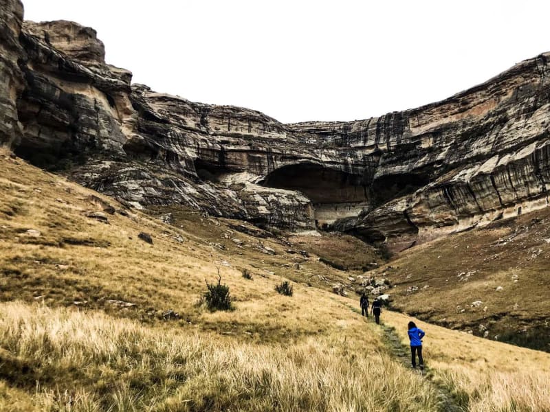 Trekking am Holkrans im Golden Gate Nationalpark: drei Trekker mit Rucksäcken wandern auf Pfad