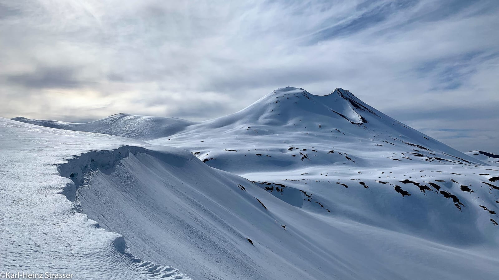 Bergtour am Vulkan Casablanca: schneebedeckter Kegelgipfel mit Schneewächte im Vordergrund.