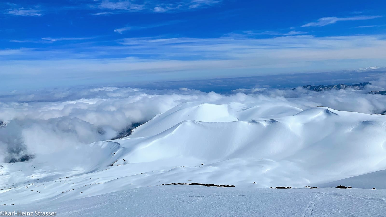 Bergtour am Wolken-Näher-Sich: tiefverschneites Hochgebirgsplateau mit Wolkenmeer, rundlichen Schneekuppen