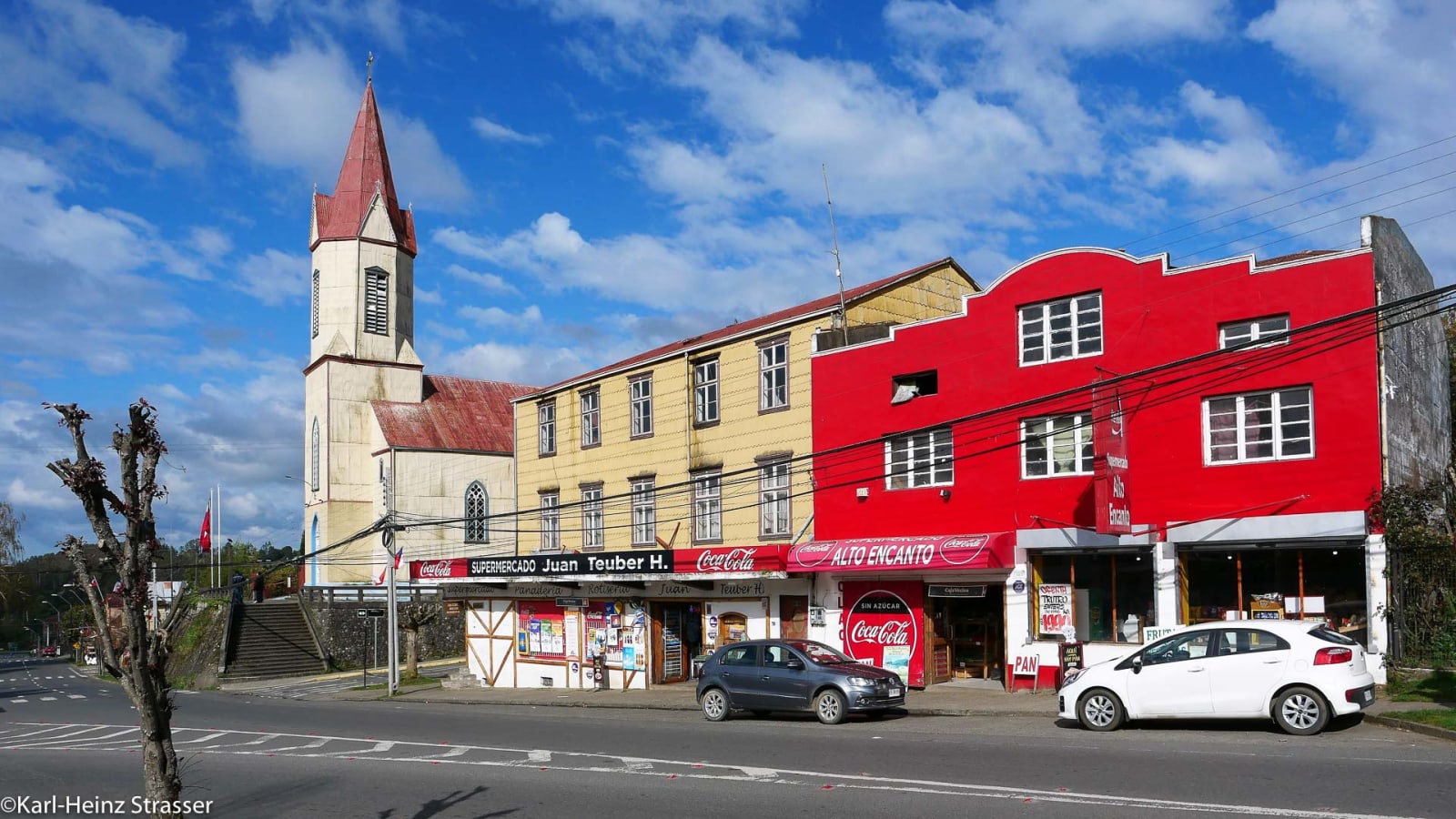 Skitour-Abschluss in Chile: Straßenszene mit weißer Kirche, rotem Metalldach und Geschäftsgebäuden.