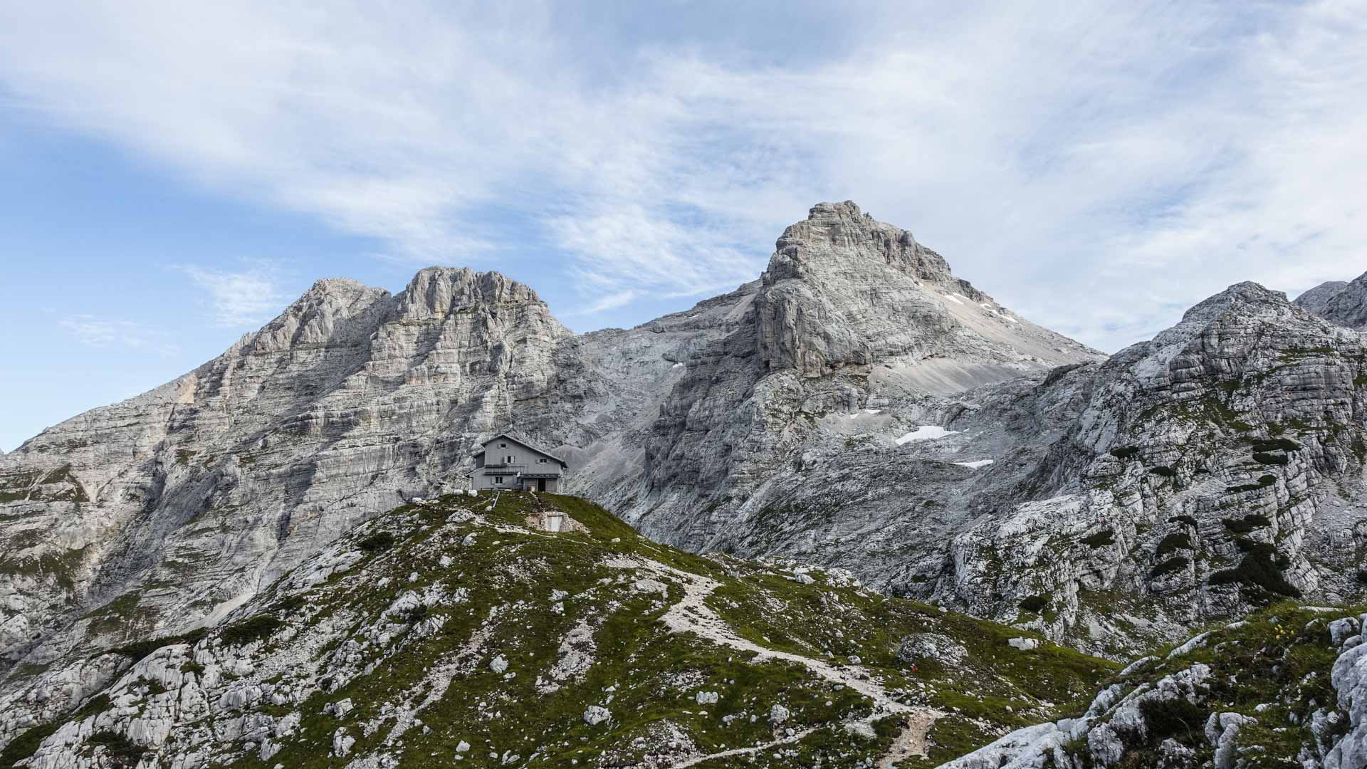 Bergwanderung Salzburg–Triest: Schutzhaus auf Felssporn zwischen Kalksteingipfeln an der Alpenüberquerung