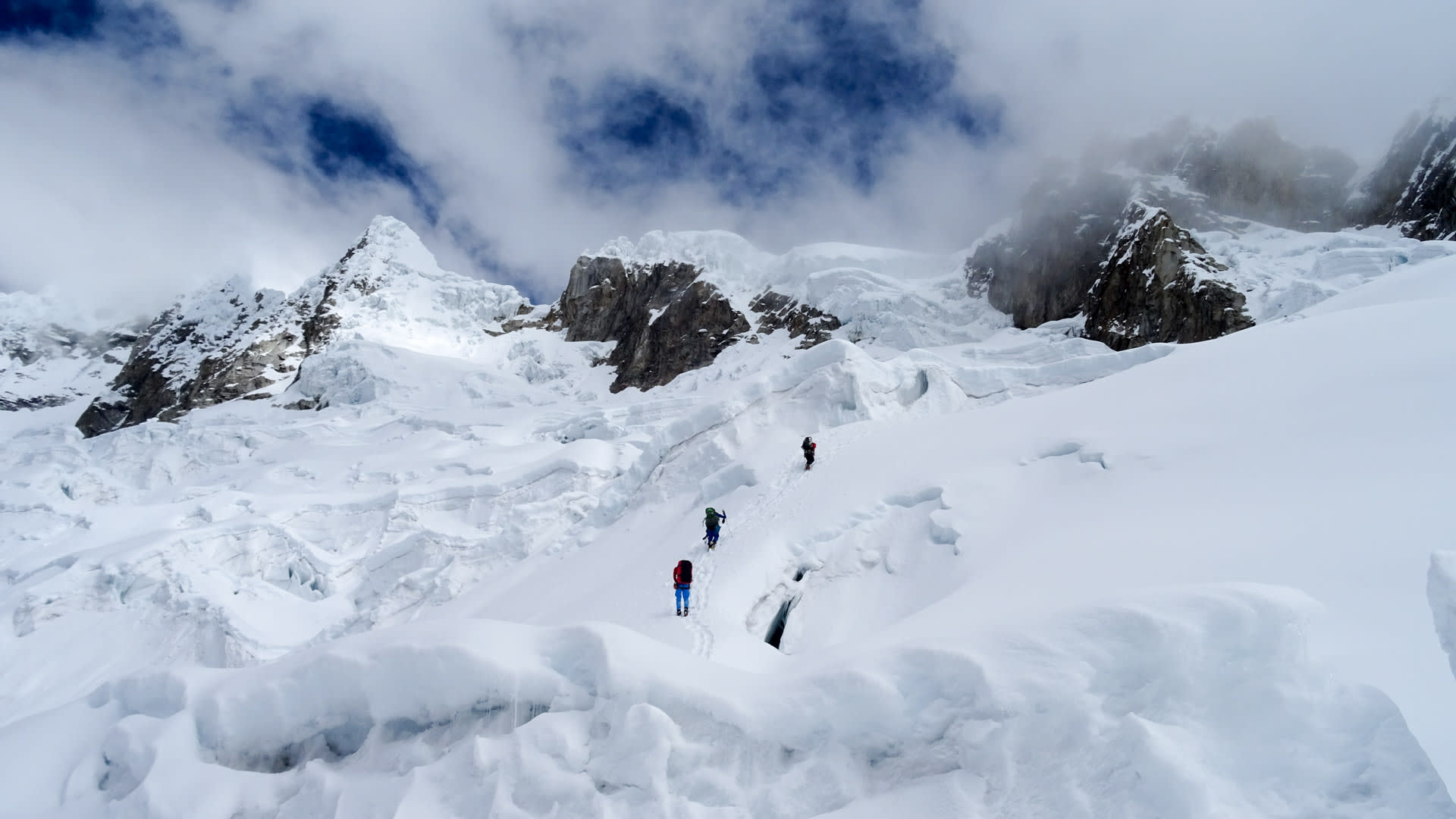 Expedition Alpamayo: drei Höhenbergsteiger in Hintereinanderformation auf zerklüftetem Gletscher am Alpamayo.
