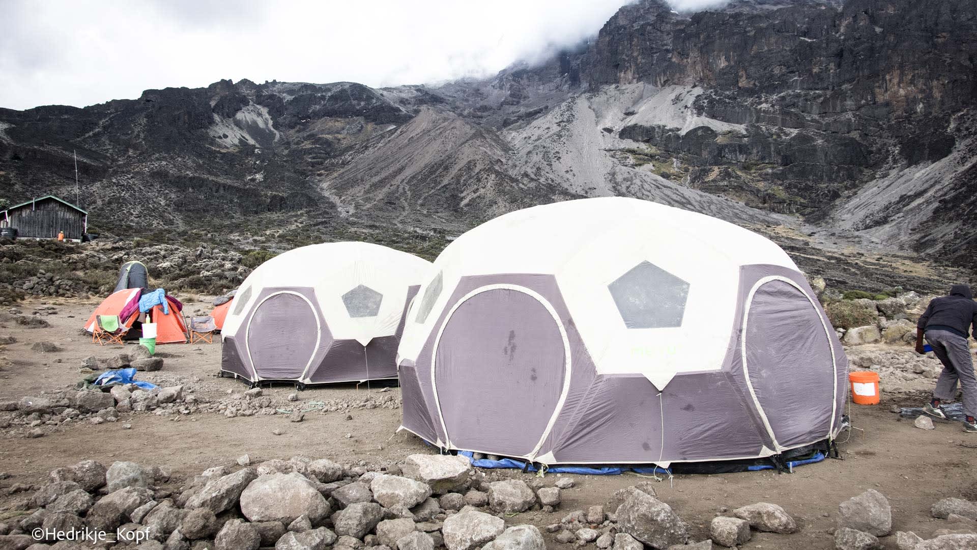 Expedition am Kilimanjaro: Kuppelzelte im Barranco Camp auf steinigem Plateau vor dunklem Felsmassiv.