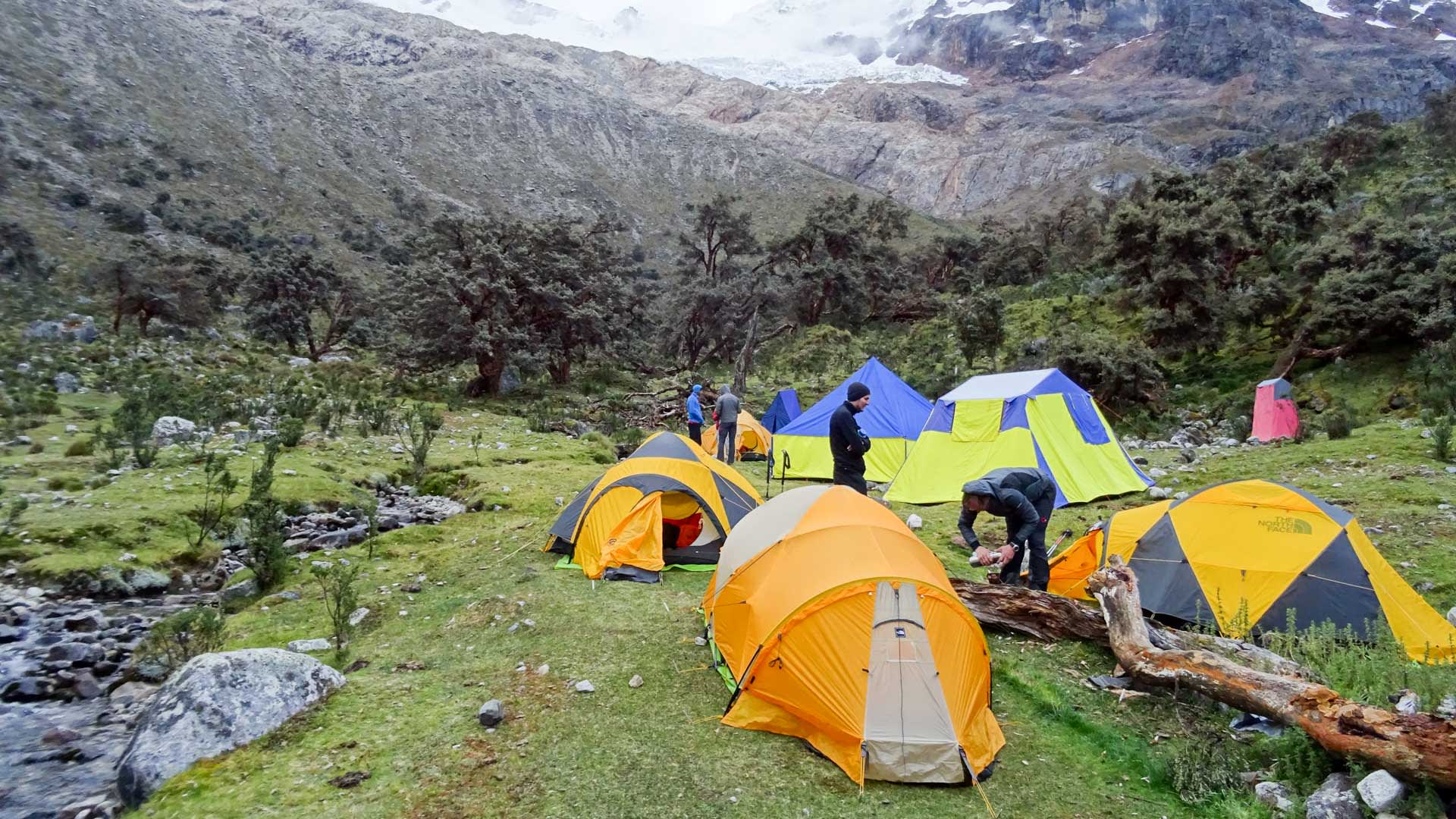 Expedition Alpamayo: Basislager mit sieben Kuppelzelten auf grasbewachsenem Hochgebirgshang unterhalb des Alpamayo.