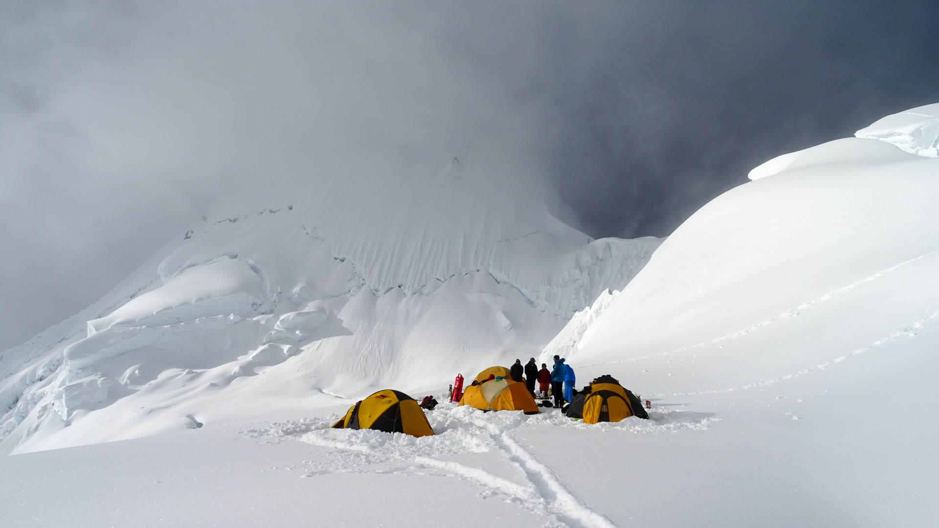 Expedition Alpamayo: vier Zelte und fünf Höhenbergsteiger im Hochlager auf schneebedecktem Gletscher am Alpamayo.