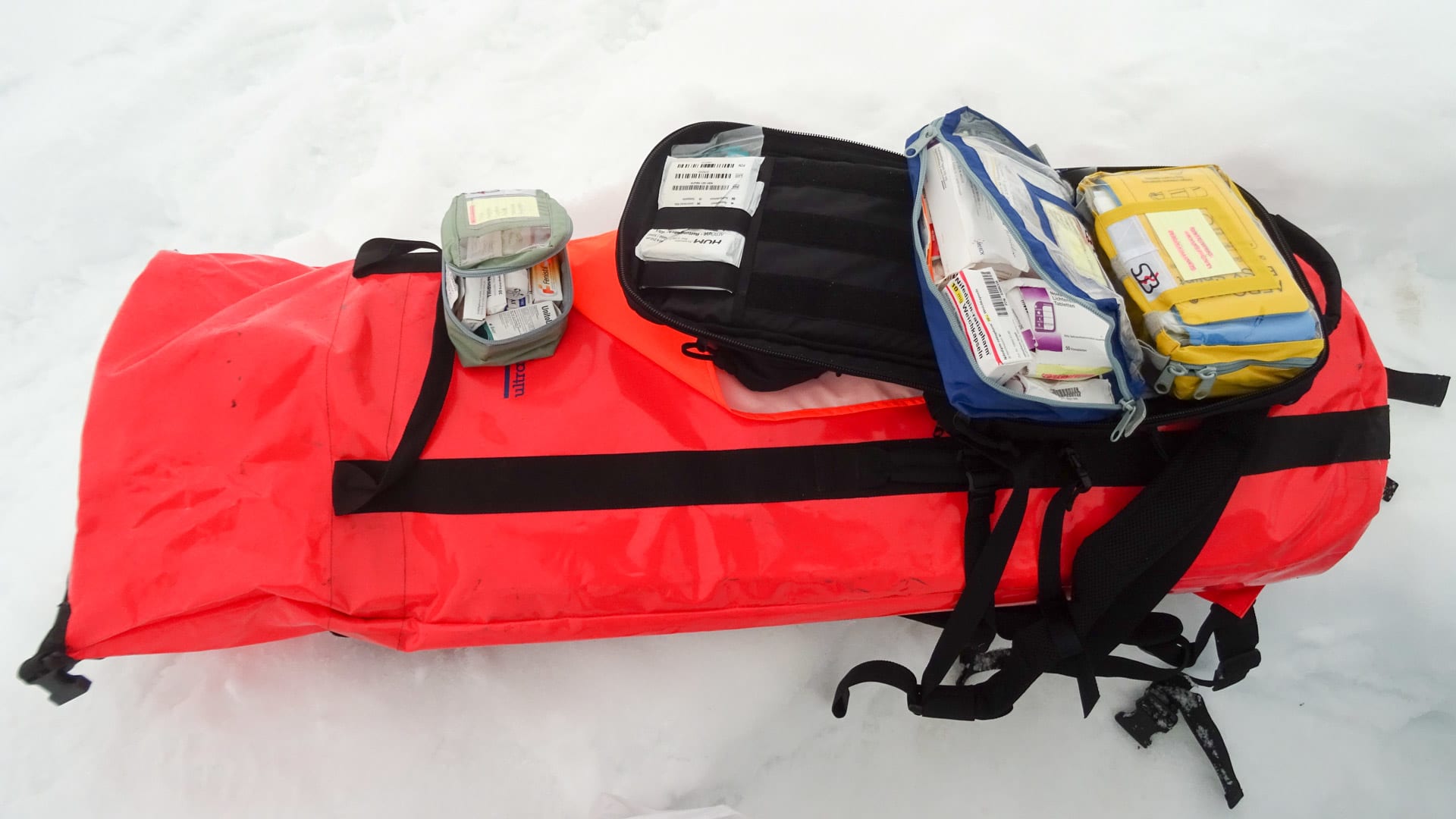 Expedition in Peru: Notfallausrüstung mit Erste-Hilfe-Taschen und Medikamenten auf Schneeuntergrund ausgelegt.
