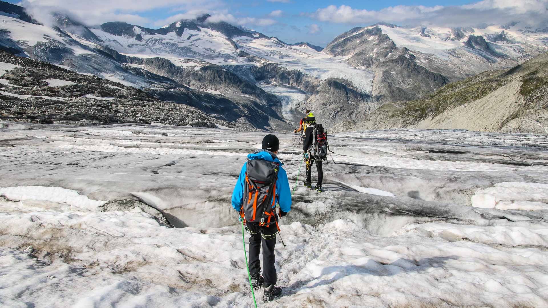 Zwei Bergsteiger traversieren am Seil gesichert das zerklüftete Gletschereis beim Anstieg zum Großvenediger.