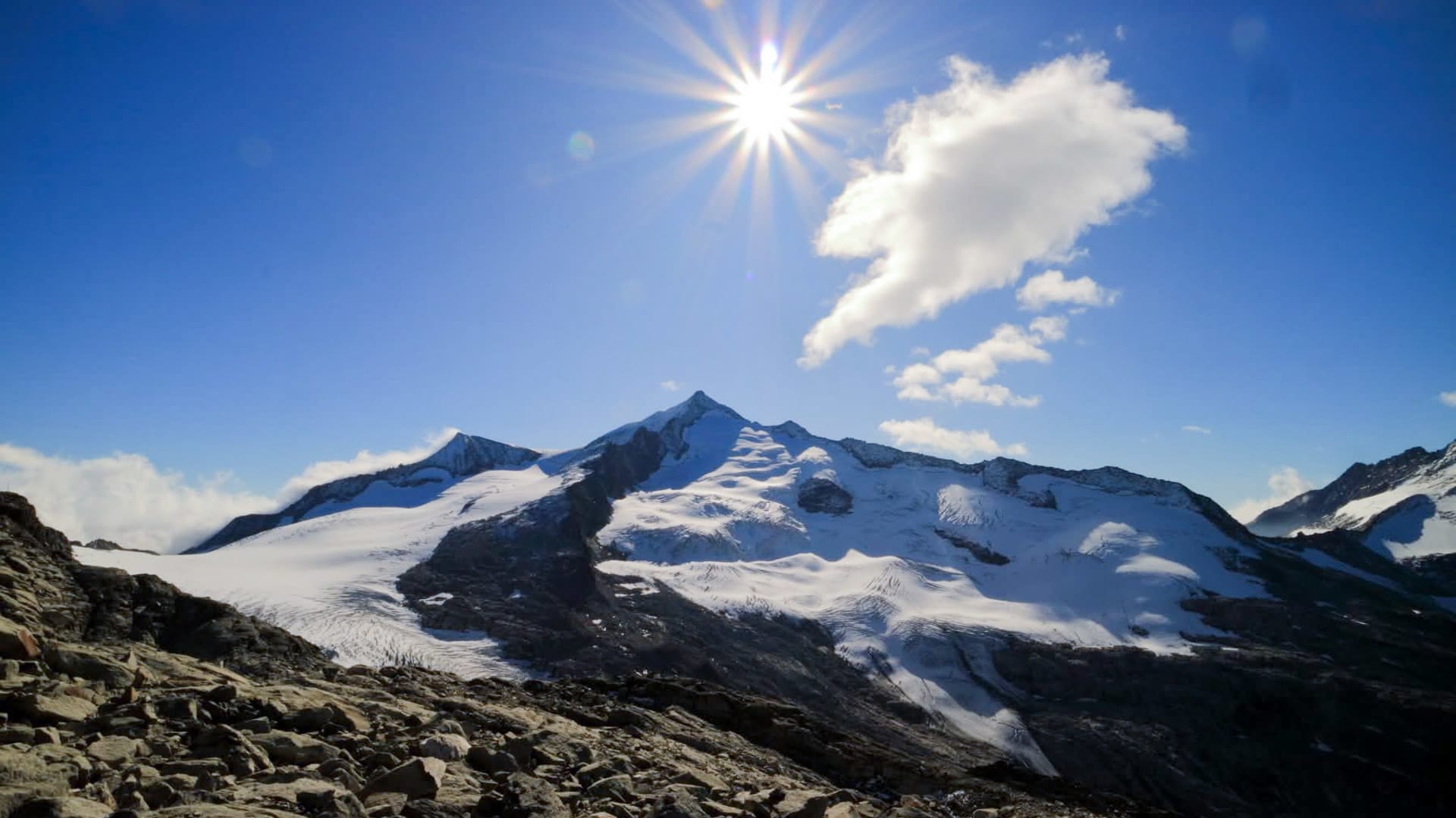 Hochtour in den Hohen Tauern: spitzer Gipfel mit Gletscher und Geröll im Vordergrund, klarer Sommerhimmel.