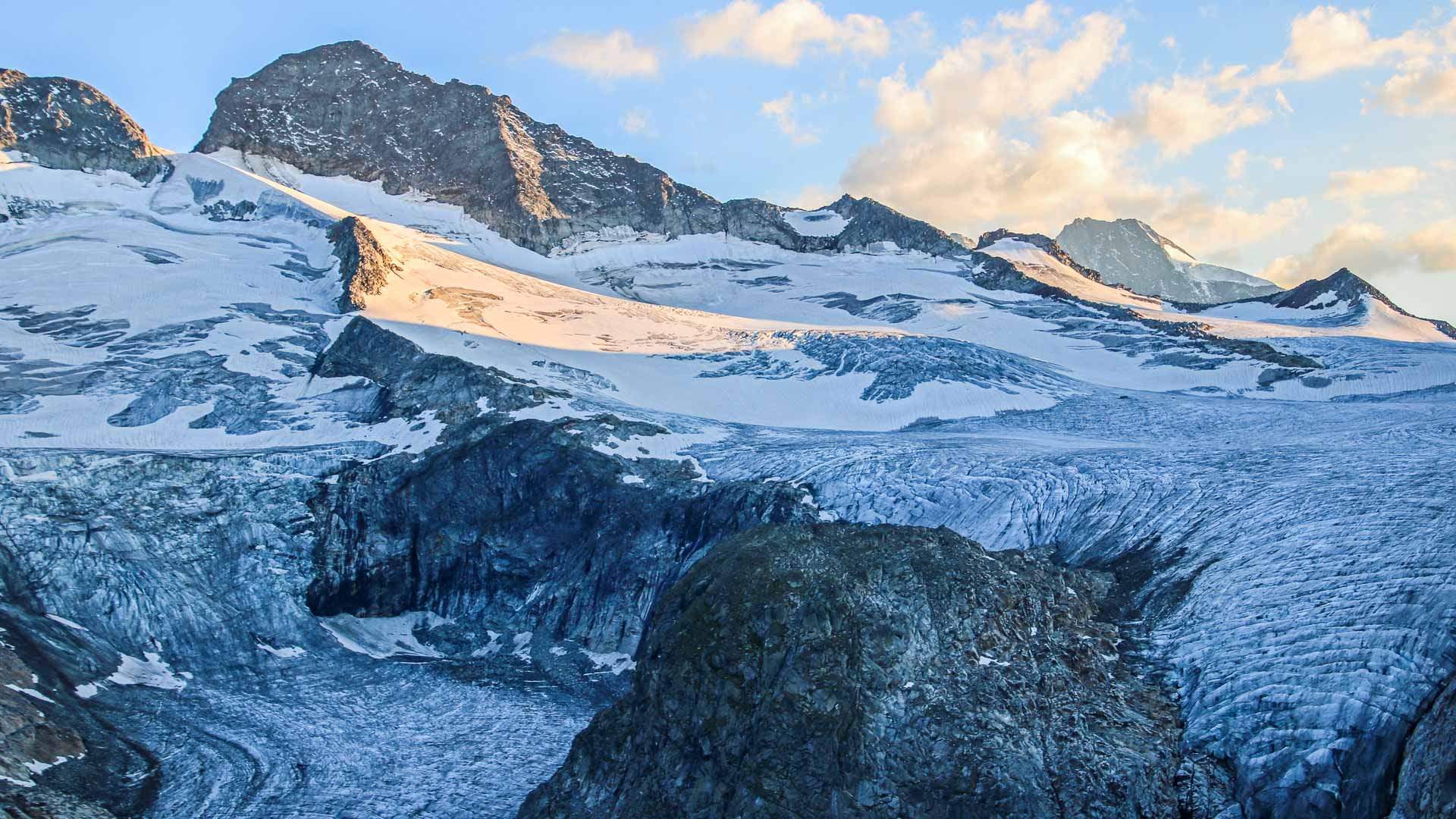 Hochtour am Großvenediger: zerklüfteter Gletscher mit tiefen Spalten und dunklem Felsgipfel im Hintergrund.