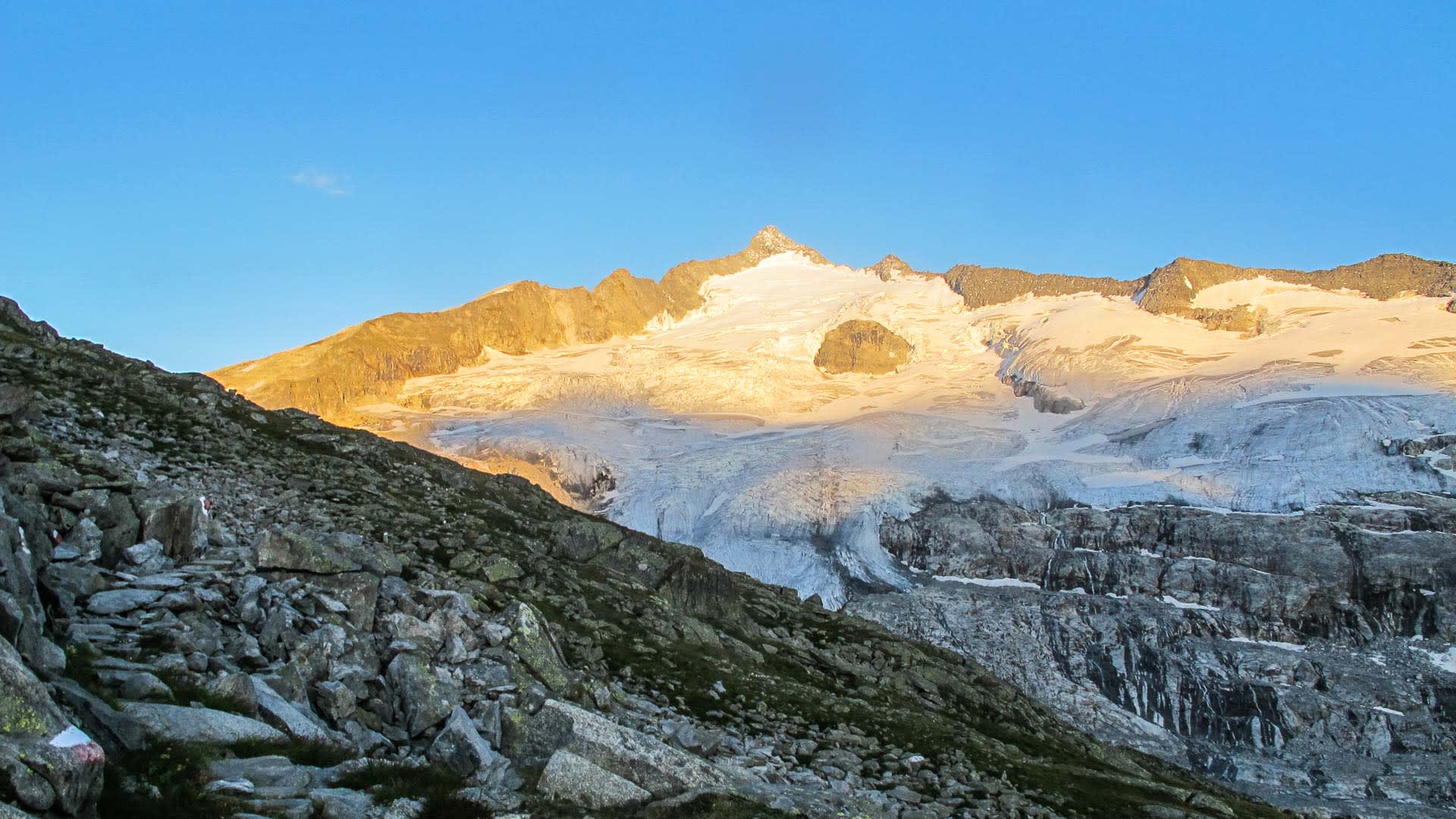 Hochtour am Großvenediger: zerklüfteter Gletscher mit Seracs und Gipfel im orangefarbenen Morgenlicht der Hohen Tauern.