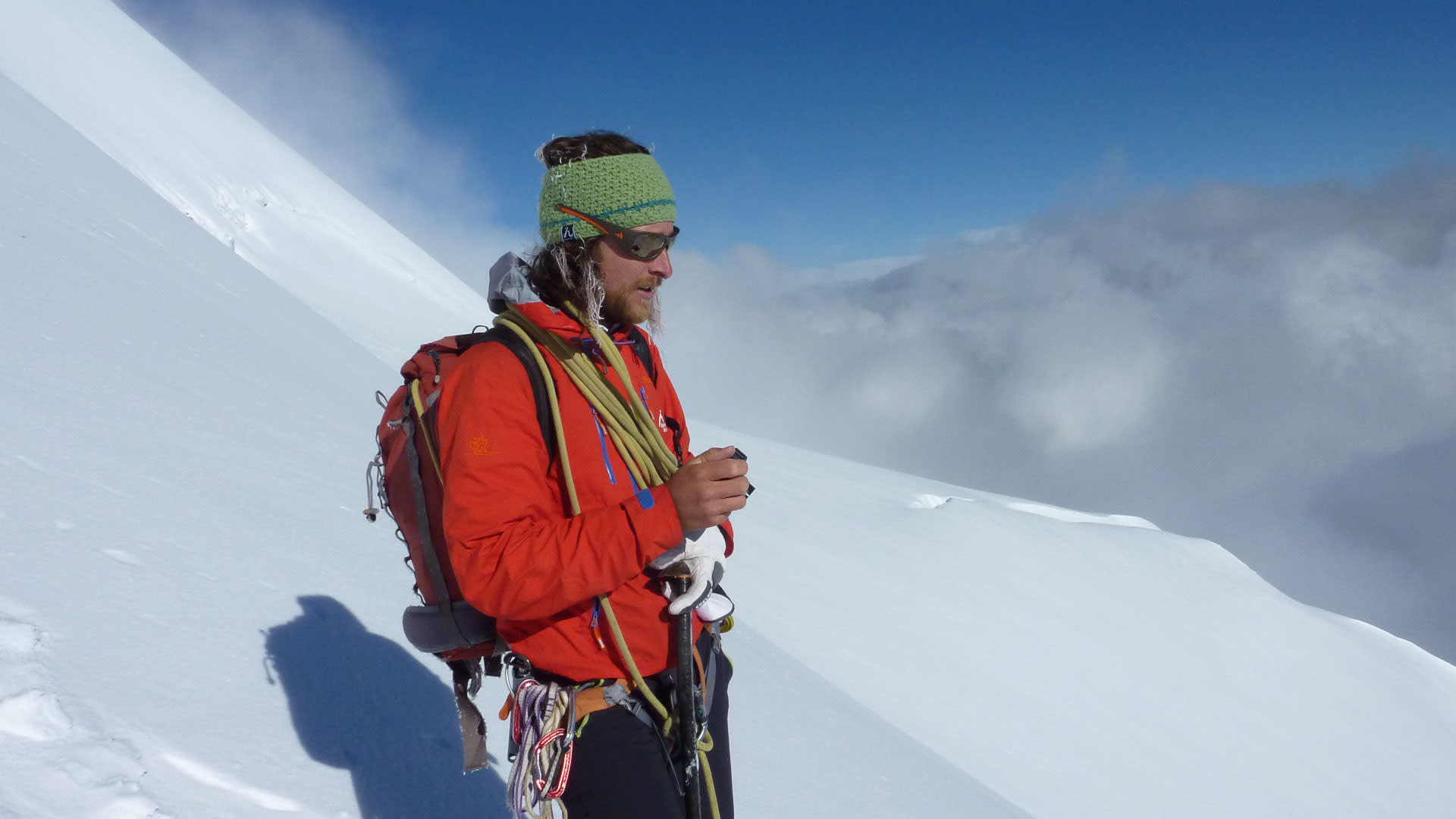 Bergsteiger mit Pickel, Seil und Klettergurt bei der Hochtour am steilen Schneehang des Piz Palü in den Bernina-Alpen.