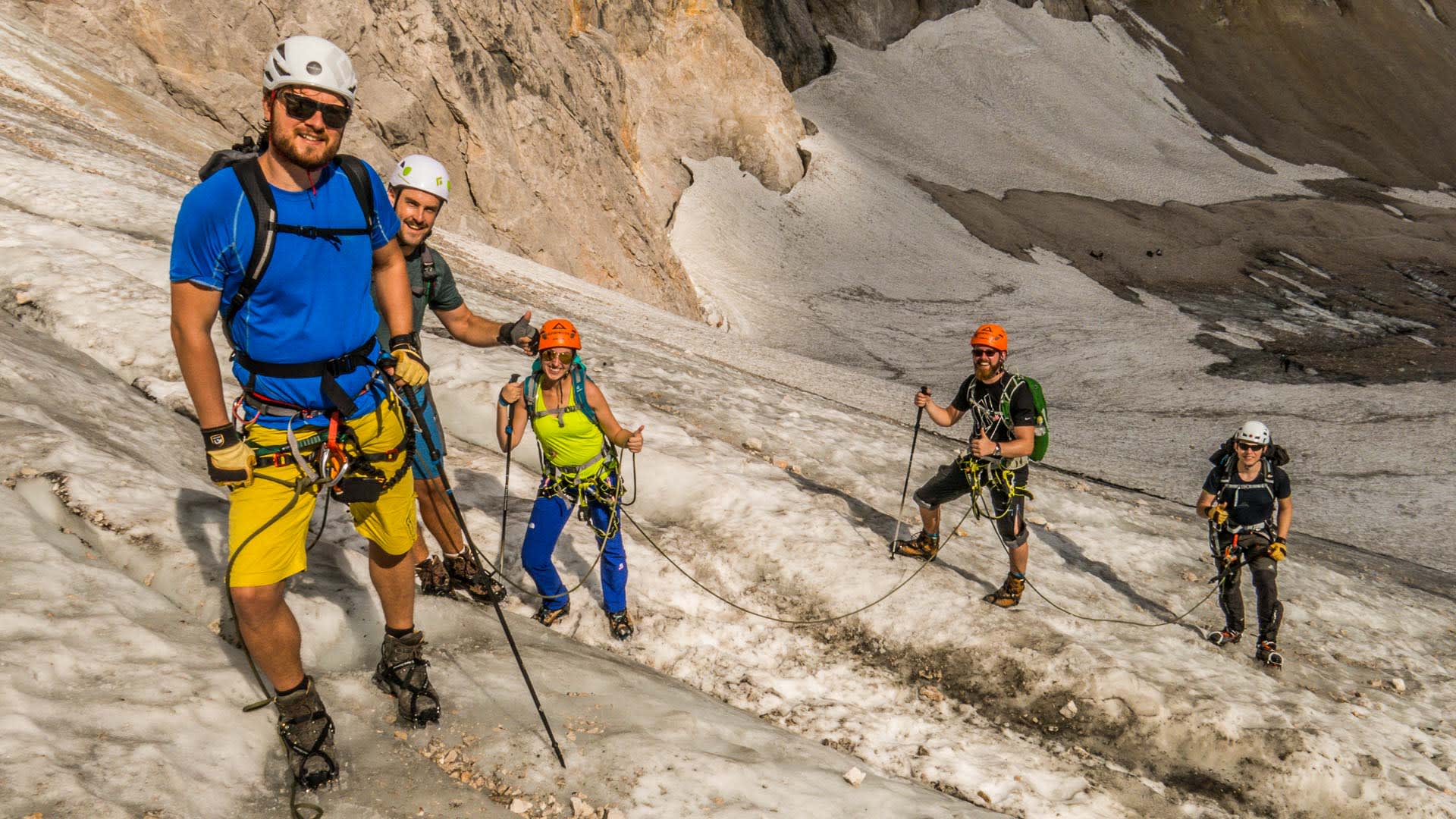 Klettersteig Zugspitze: fünf Klettersteiggeher mit Steigeisen traversieren den Höllentalgletscher im Seil.