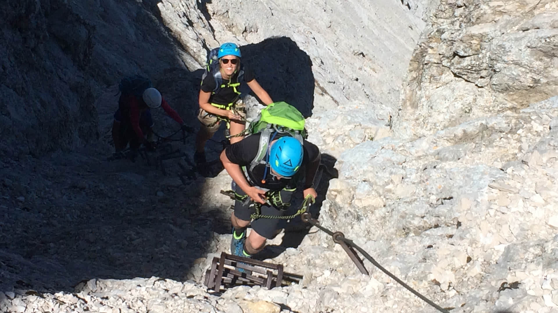 Klettersteig Via Ferrata an der Alpspitze: Klettersteiggeher an Eisenbügeln im Kalkfels, zwei weitere Personen dahinter.