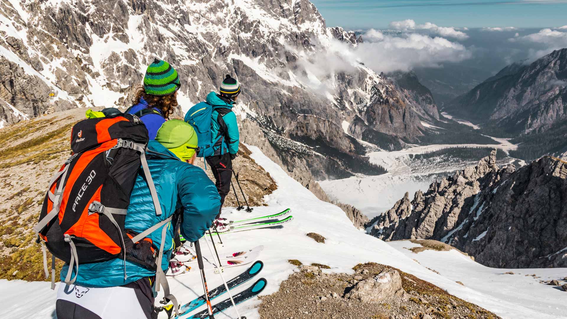 Drei Skitourengeher stehen am Grat vor der Einfahrt in den Seilergraben auf der Großen Reibn.