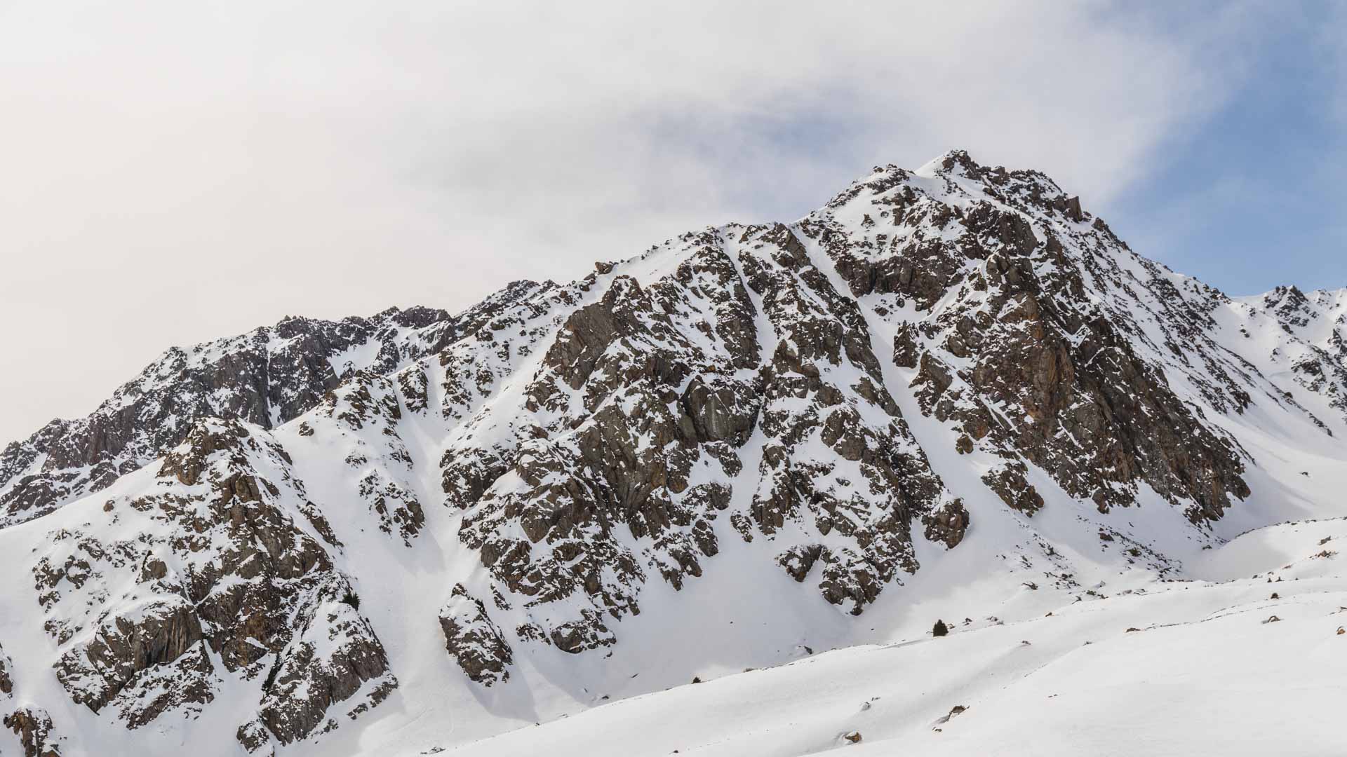 Skitour im Tien Shan: felsige Bergflanke mit schneebedeckten Rinnen bei Jergalan in Kirgistan.