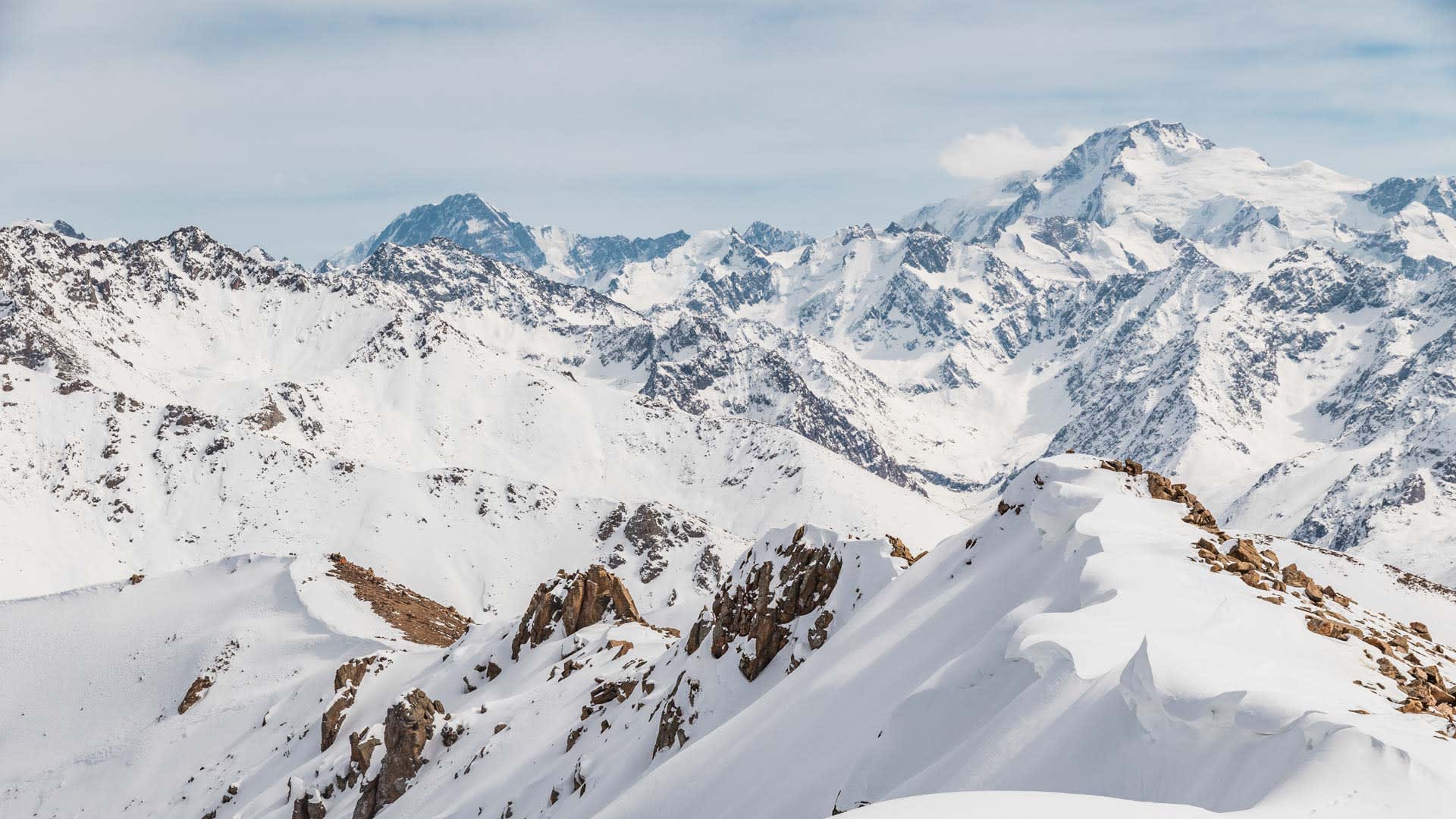 Skitour im Tien Shan: verschneite Felsgrate und vergletscherte Hochgipfel in Kirgistan im Winter.