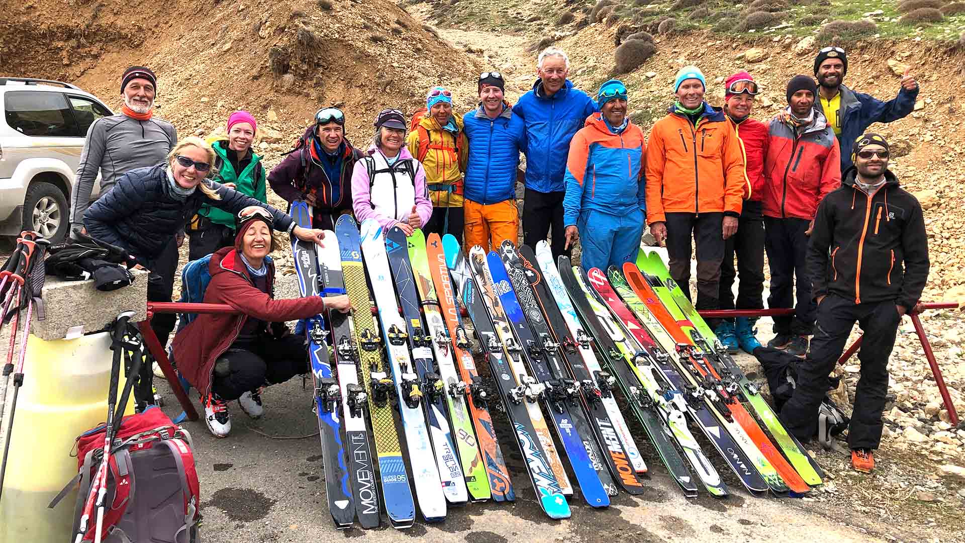 Gruppe von Skitourengehern posiert mit aufgereihten Tourenskien vor dem Aufstieg zum Damavand im Iran.