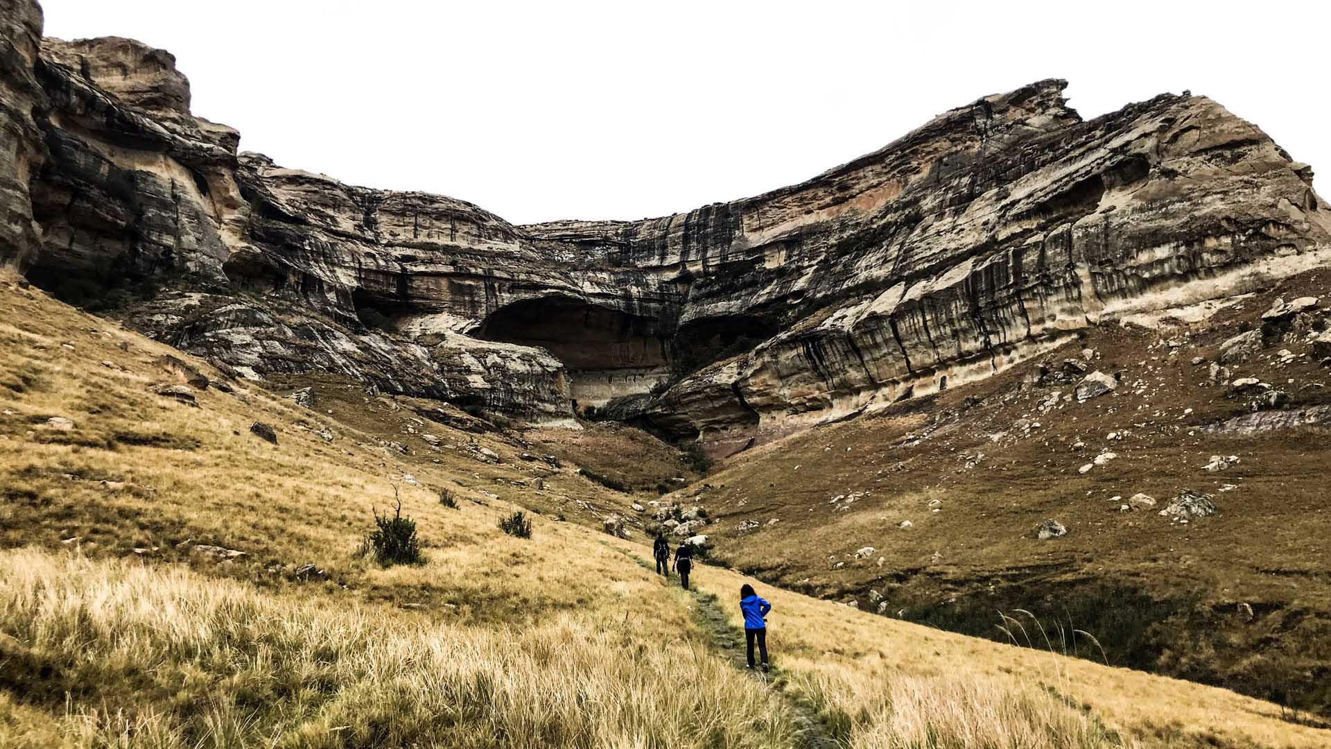 Trekking am Holkrans im Golden Gate Nationalpark: drei Trekker mit Rucksäcken wandern auf Pfad