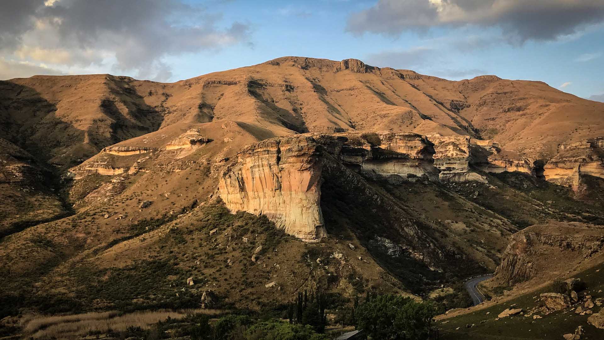 Trekking im Golden Gate Nationalpark: Panoramaansicht einer senkrechten Sandsteinwand mit Schichtung in Beige und Orange