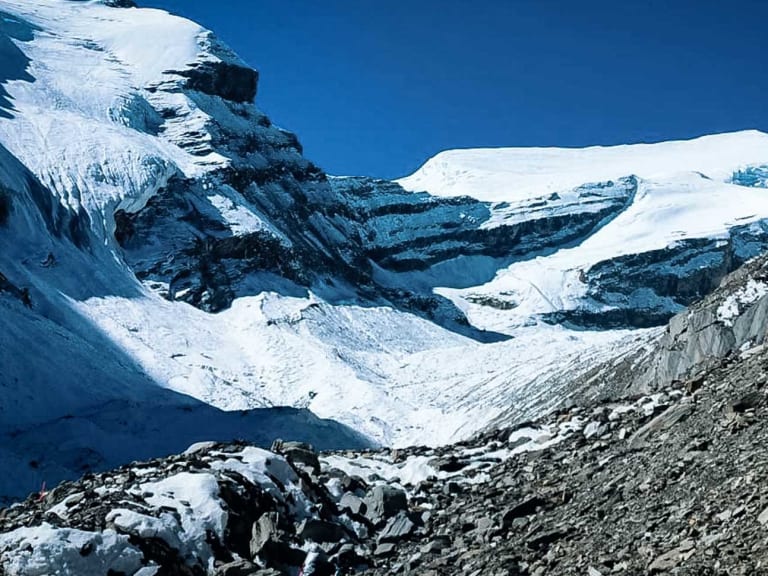 Expedition Putha Hiunchuli: Weitläufiger Gletscher mit Seracs, Gletscherspalten und dunkler Moräne unter tiefblauem Himmel.