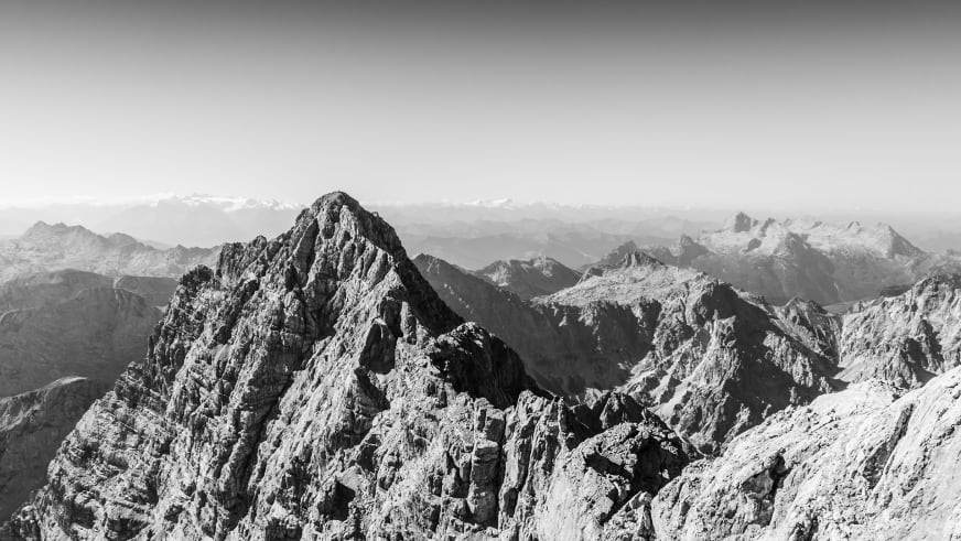 Bergwanderung auf der Watzmannüberschreitung zur Südspitze bei Berchtesgaden: zerklüfteter Kalkfelsgrat mit Bergsilhouette