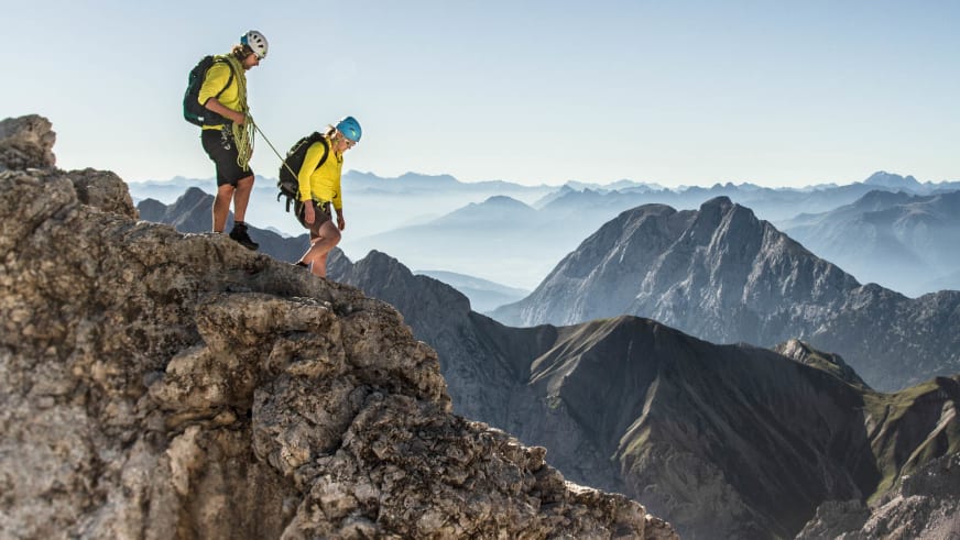 Klettersteig am Jubiläumsgrat: zwei Personen mit Helm und Seil auf dem Kalkfelsgrat der Zugspitze im Sommer.