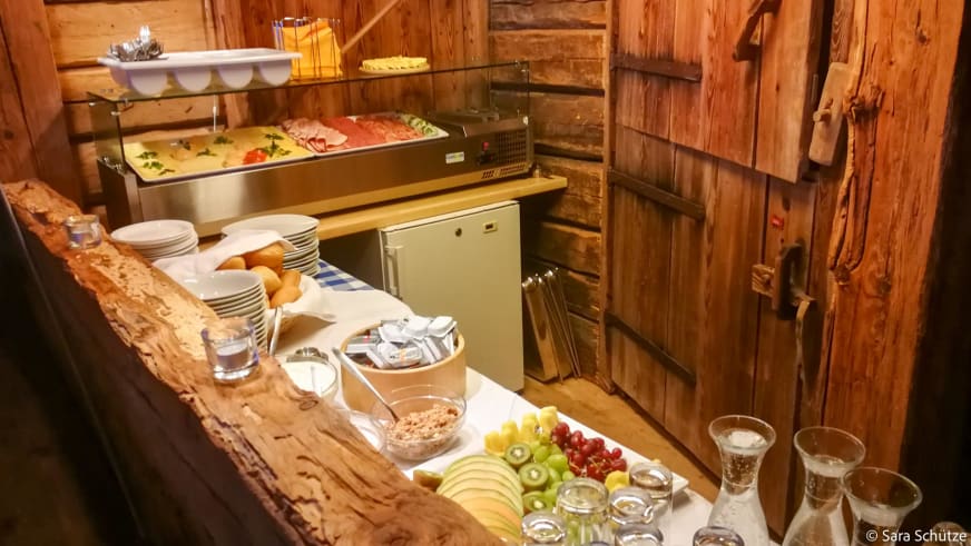 Frühstücksbuffet mit Früchten, Brötchen, Müsli und Aufschnitt in der rustikalen Oberen Maxlraineralm – Einkehr