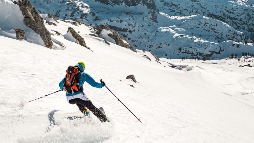 Skitour am Funtenseetauern: ein Skitourengeher faehrt in blauer Jacke einen verschneiten Steilhang der Grossen Reibn ab.
