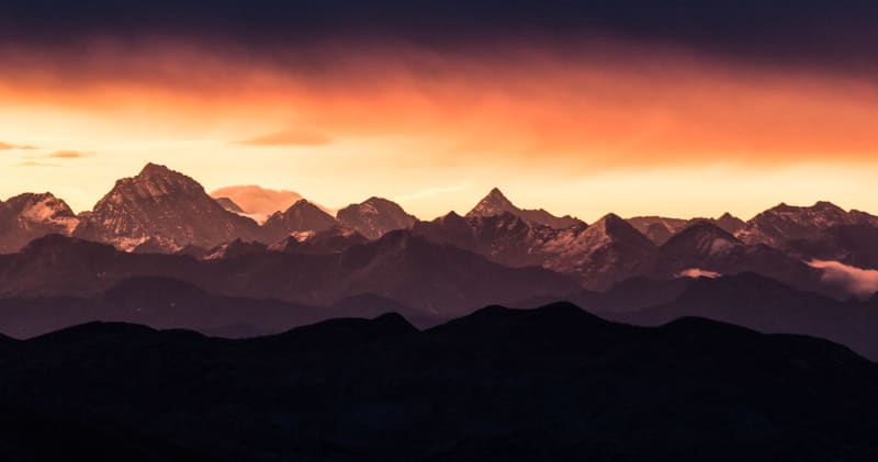 Bergtour am Watzmann: Panorama der gestaffelten Hochgebirgskette mit schneebedeckten Gipfeln im orangeroten Licht