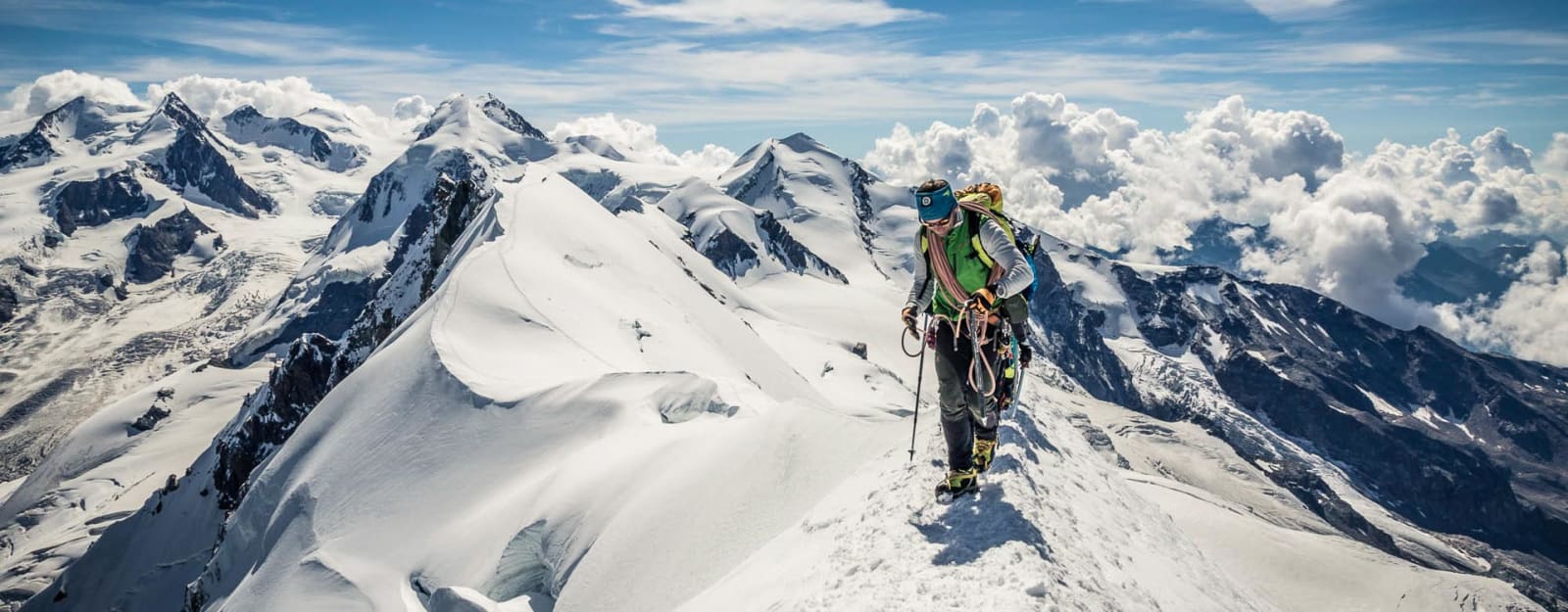 Bergtour auf der Spaghettirunde im Wallis: Bergsteiger mit Steigeisen und Kletterausrüstung auf schneebedecktem Hochgebirgsgrat.
