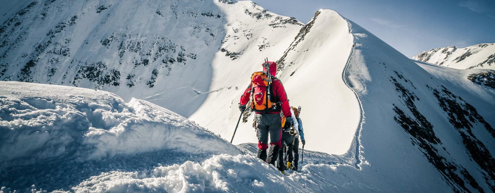 Zwei Bergsteiger steigen auf einem schmalen, schneebedeckten Grat bei der Hochtour in Zermatt auf.