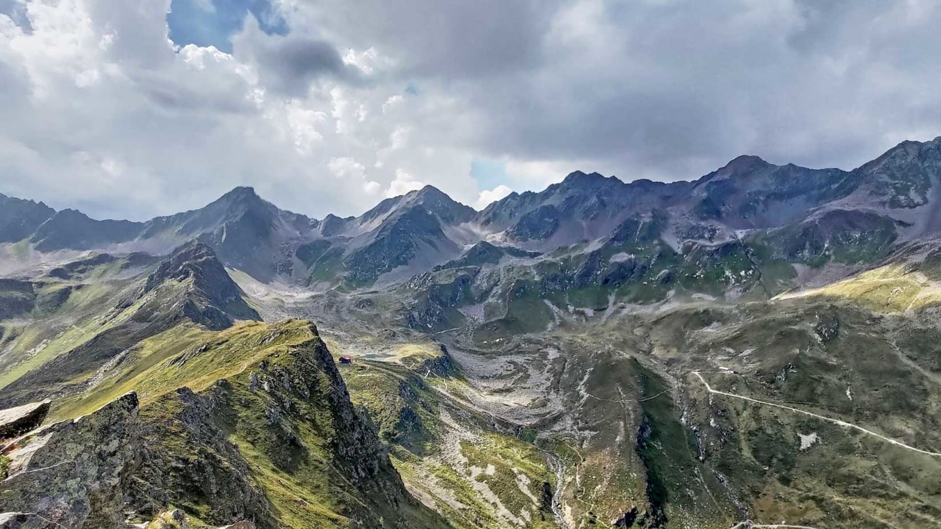 Bergwanderung auf der Verwallrunde: Blick vom felsigen Grat über Schuttfelder und Geröllhalden auf die Bergkette der Verwallgruppe.