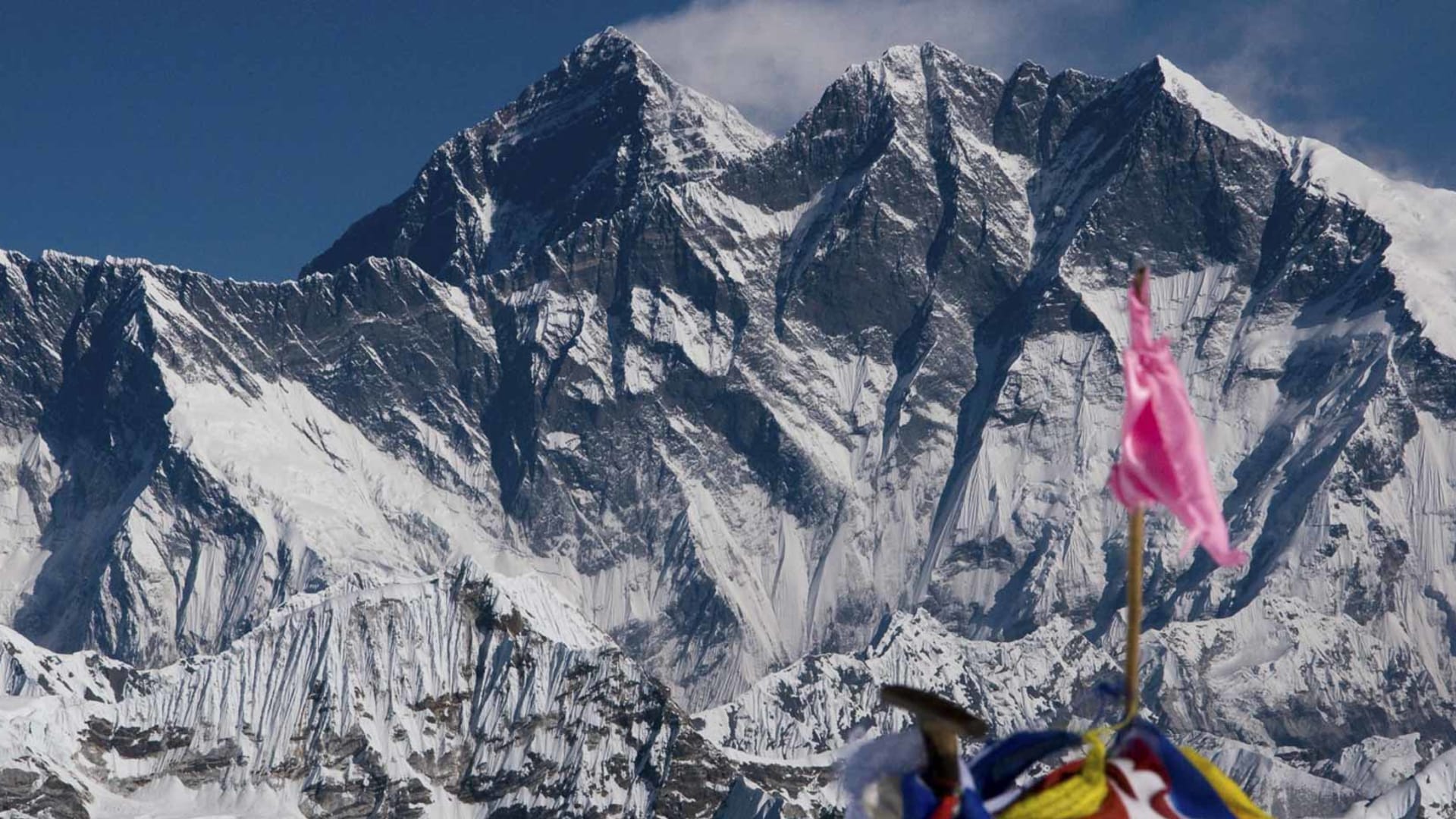 Expedition auf den Mera Peak Central in Nepal: Blick vom Gipfel auf die vergletscherte Himalaya-Bergwand mit Gebetsfahnen